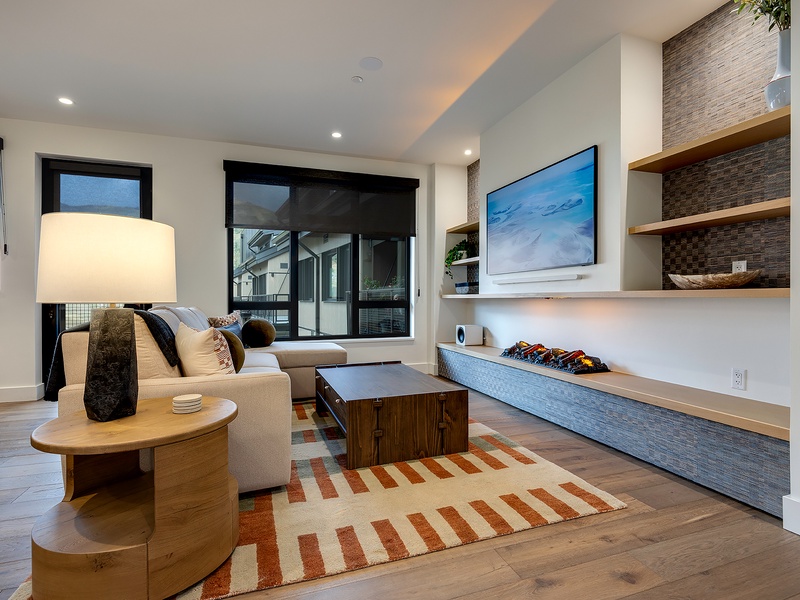 Unwind in your contemporary living space, where natural light pours through expansive windows and thoughtful design meets modern comfort, perfect for relaxing evenings.