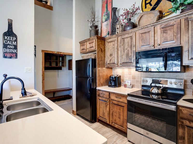 Your fully equipped kitchen features rustic wood cabinetry, modern appliances, and charming details—perfect for preparing meals at home after exploring the area.