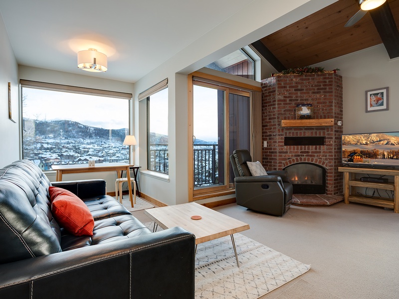 Cozy living room with a warm fireplace, mountain views, and vaulted ceilings—your perfect retreat after a day of adventure.