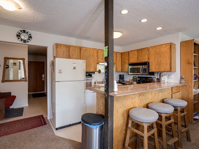 Your fully-equipped kitchen awaits with everything you'll need—stove, microwave, coffee maker, and ample counter space for preparing meals during your stay.