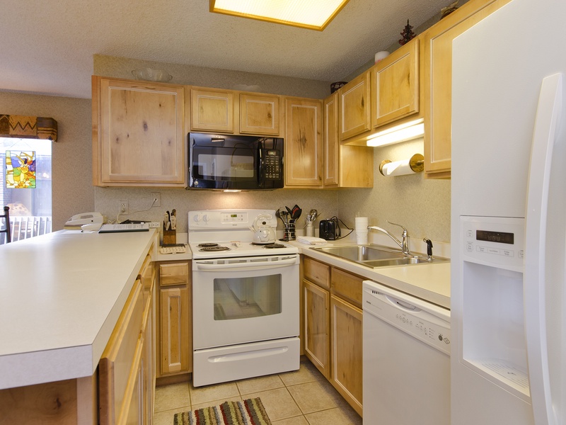 Your fully equipped kitchen awaits with warm wood cabinetry, modern appliances, and everything you need to prepare memorable meals during your stay.