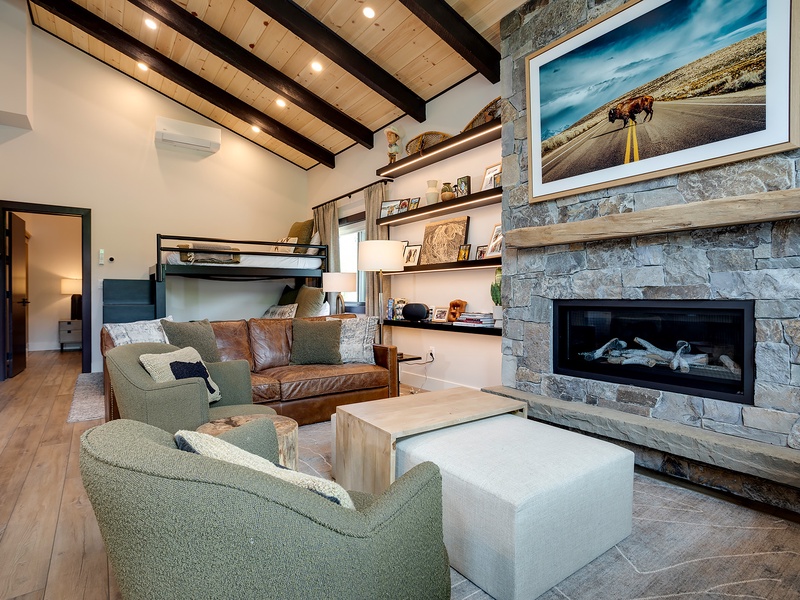Cozy up in your open-concept living room with rustic exposed beams, stone fireplace, and thoughtful sleeping arrangements for the whole family.