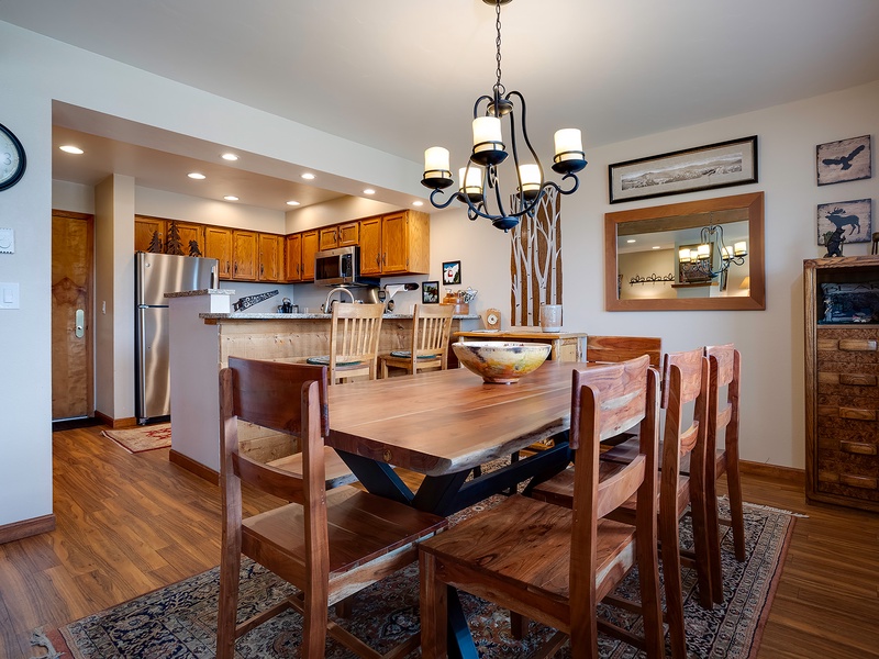 Gather around this handcrafted dining table where your group can share meals and make memories. The open layout flows into a fully equipped kitchen, perfect for cooking together and enjoying your mountain getaway.
