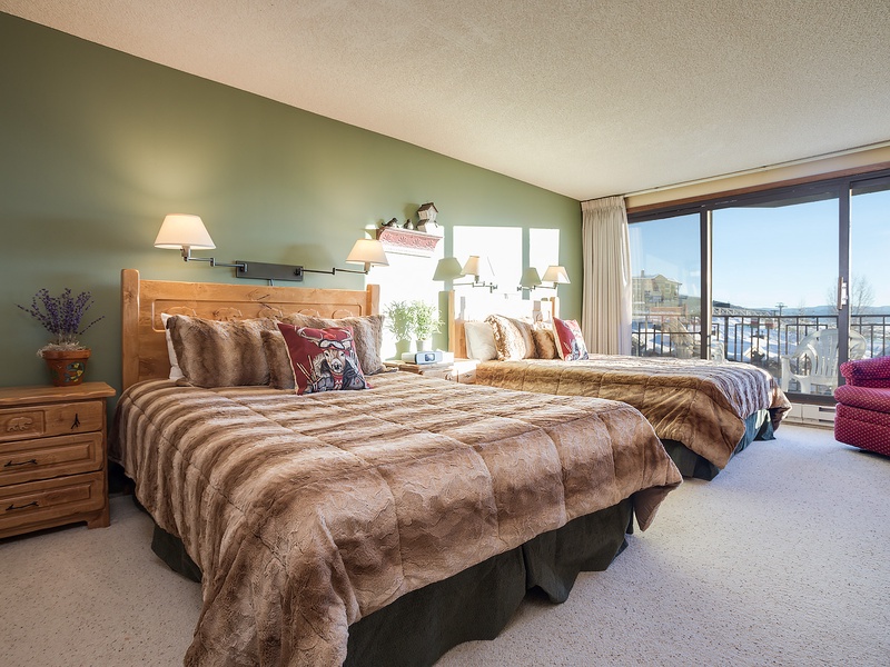 Sink into plush beds wrapped in soft faux fur as natural light pours through floor-to-ceiling windows, framing lake views that greet you each morning in your peaceful retreat.