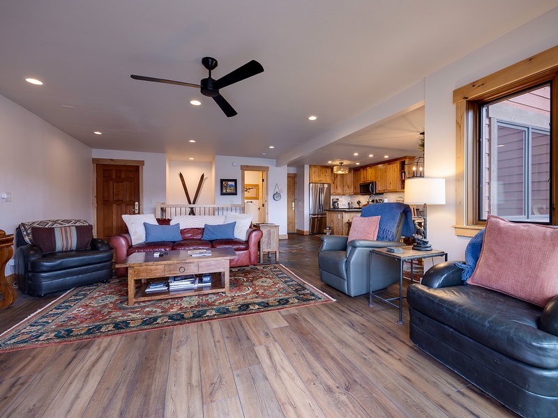 Unwind in your spacious living room with vaulted ceilings, plush leather seating, and an open layout that flows into a fully-equipped kitchen—perfect for relaxing after a day of exploring.