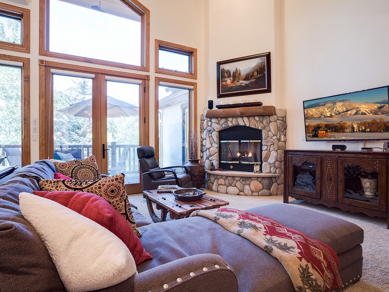Sink into plush seating before a crackling stone fireplace while you enjoy mountain views through soaring windows and crisp, snowy scenery beyond your doorstep.