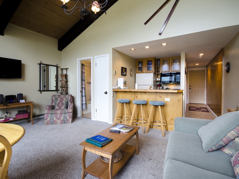 You'll love gathering in this open living space where vaulted ceilings with rustic beams create an airy feel and the fully equipped kitchen bar invites conversation over morning coffee or après-ski snacks.