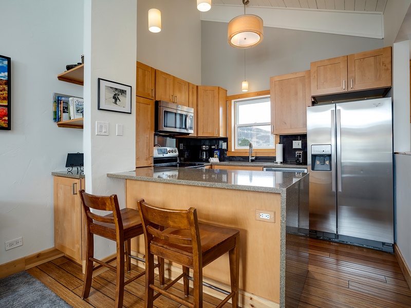 Your fully equipped kitchen features granite countertops, stainless steel appliances, and a breakfast bar where you can enjoy morning coffee or casual meals with mountain views.