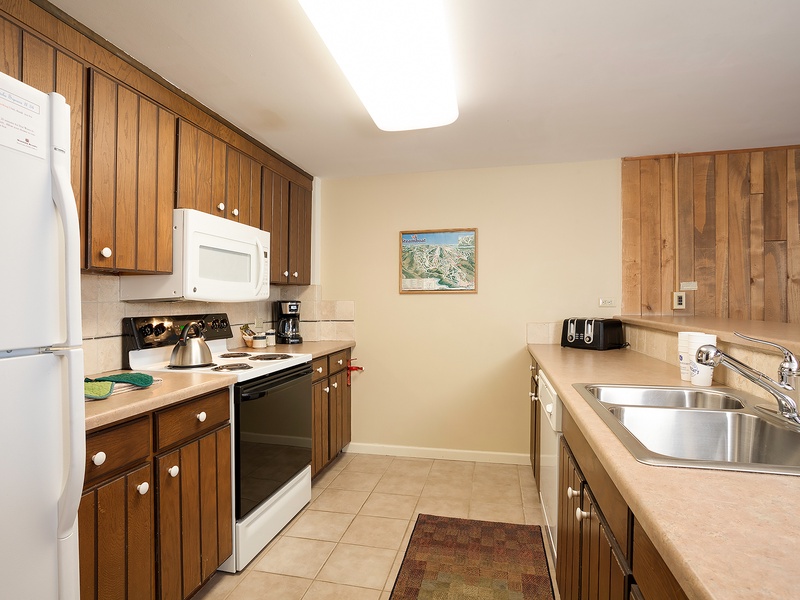 Your fully equipped kitchen provides everything you need to prepare meals during your stay, with warm wood cabinetry, modern appliances, ample counter space, and a homey mountain-inspired ambiance that makes cooking feel effortless.