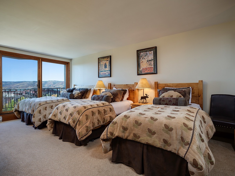 Wake up to stunning mountain vistas in your inviting bedroom, where rustic charm meets comfort. Three cozy beds and soft lighting create the perfect retreat after your day of adventure.