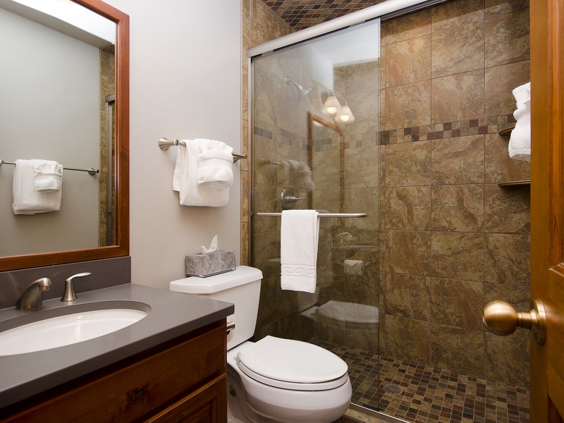Refresh after your adventures in this beautifully appointed bathroom with elegant stone tile, walk-in shower, and plush towels awaiting your arrival.