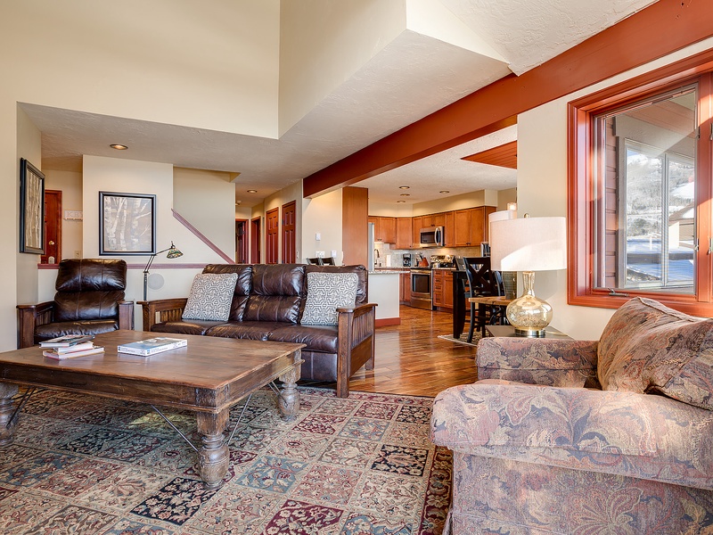 Unwind in your spacious open living area, where rich wood tones, comfortable seating, and warm natural light create the perfect retreat after a day of adventure.