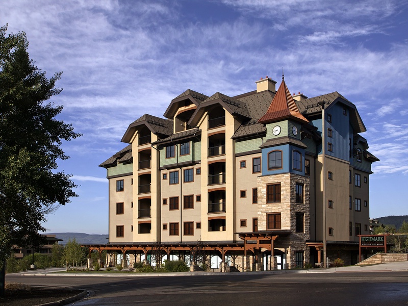 Multi-story vacation rental building featuring distinctive European-inspired architecture with a clock tower, stone accents, and mountain views in the surrounding area.