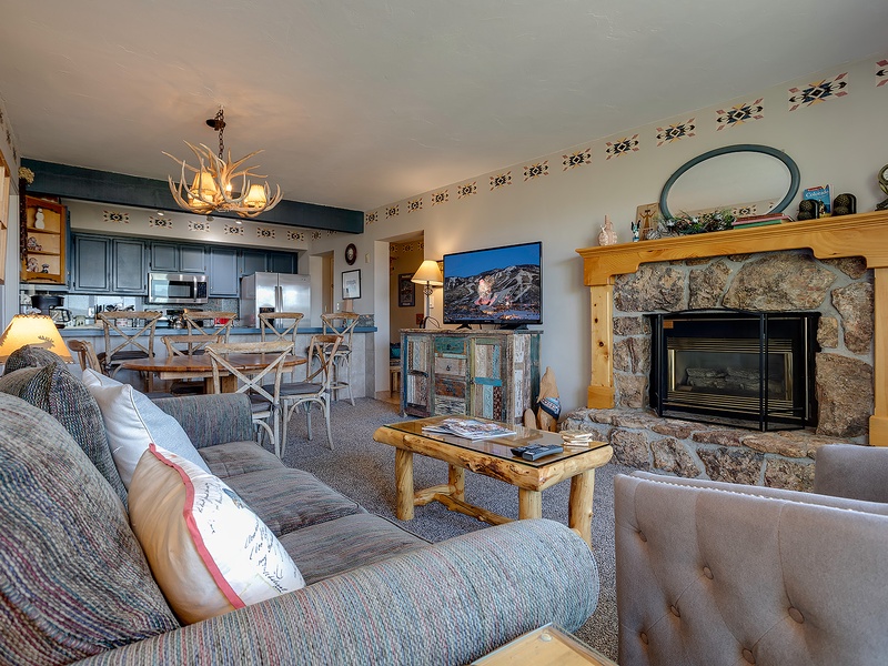 Cozy mountain retreat with rustic stone fireplace, open-concept living and dining, and a fully equipped kitchen perfect for your alpine getaway.