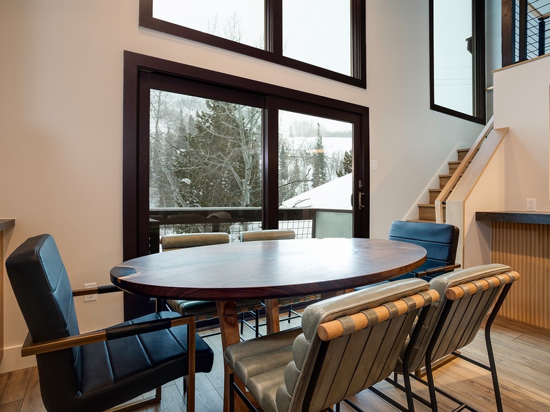 Gather around this elegant dining table with snowy mountain views streaming through floor-to-ceiling windows, where meals become memorable moments in your alpine retreat.