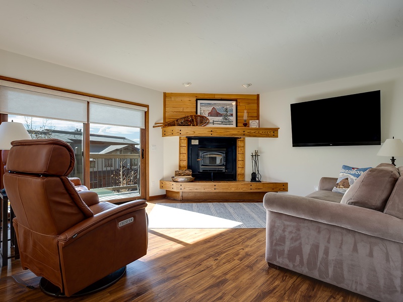 Sink into plush seating beside the warm glow of your fireplace, where sunlight streams through large windows and a flat-screen TV awaits your favorite shows.
