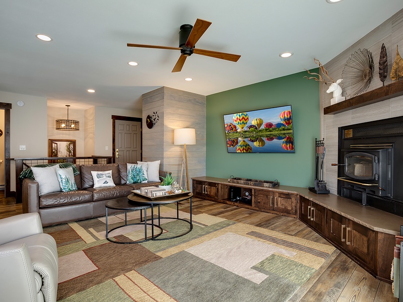 You'll love unwinding in this stylish living room with its cozy fireplace, comfortable leather seating, and modern entertainment setup—perfect for relaxing after your adventures.