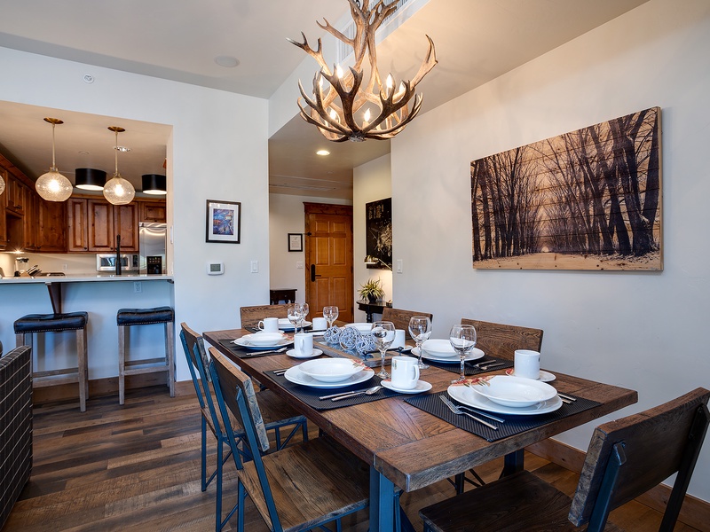Gather around your rustic dining table under the striking antler chandelier, where mountain-inspired elegance meets comfort. The open-concept space flows effortlessly into a well-equipped kitchen, perfect for your group meals.