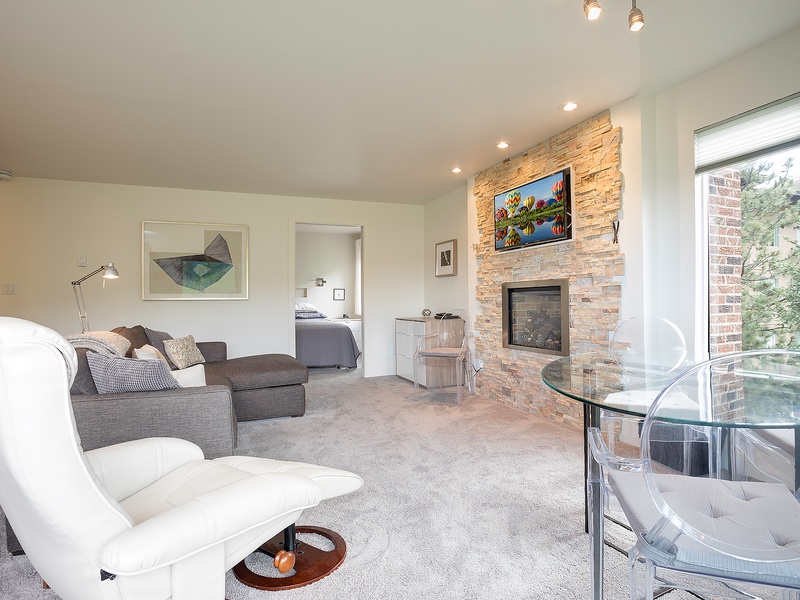 Unwind in your spacious living area with plush seating, a warm fireplace, and large windows inviting natural light. Perfect for relaxing after a day of adventures.