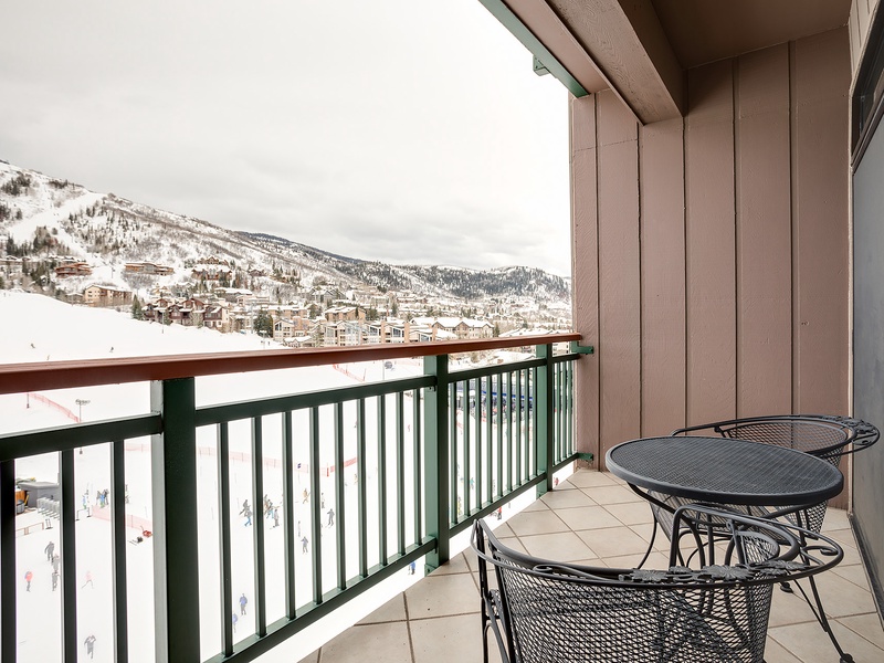 Enjoy breathtaking mountain views from your private balcony, where cozy seating invites you to sip morning coffee while soaking in the alpine beauty.