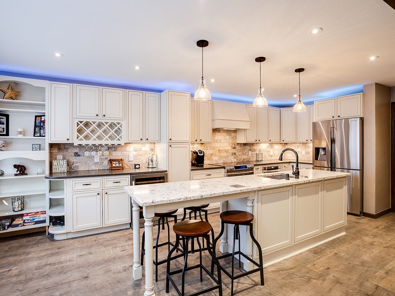 Gather around this spacious kitchen island with elegant white cabinetry, granite countertops, and modern appliances—perfect for whipping up your favorite meals and making memories.