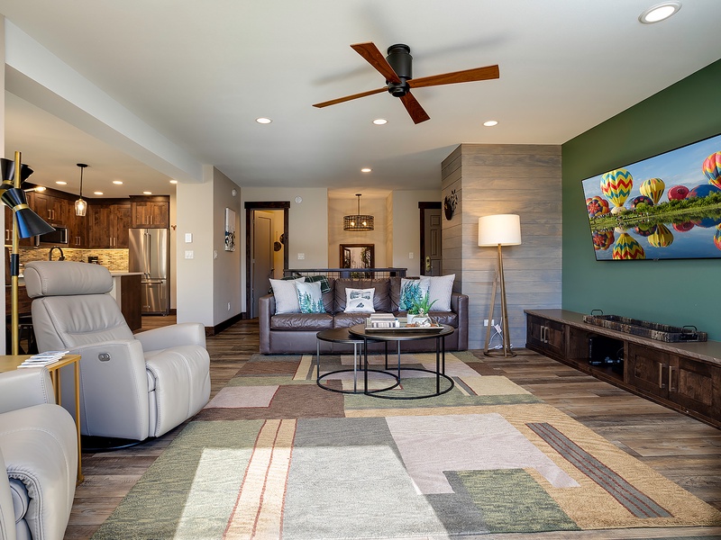 Sink into plush seating where warm wood tones meet modern comforts—your retreat features a smart TV, stylish furnishings, and an open flow to a fully equipped kitchen.
