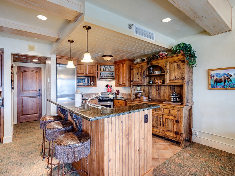 Step into your beautifully crafted kitchen with rich wood cabinetry, granite countertops, and a charming island perfect for morning coffee or evening meals.