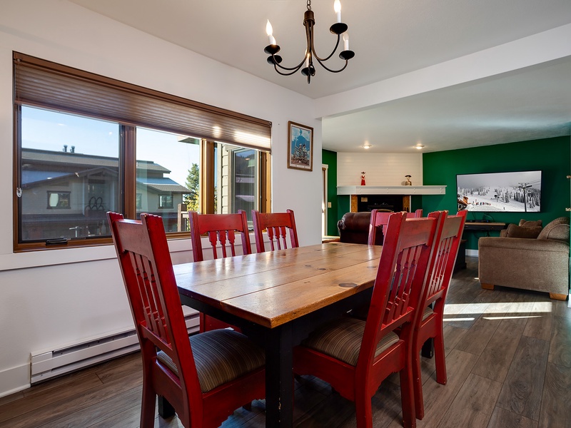 Gather around this inviting dining table where the vibrant red chairs and rich wood tones create the perfect setting for your group meals and mountain memories.