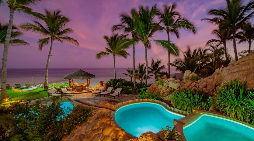 Gorgeous patio with pool and beach view during sunset