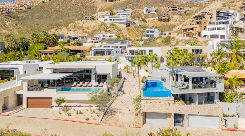 Modern hillside villas showcase stunning architectural design with private pools nestled among desert landscape and tropical palms.