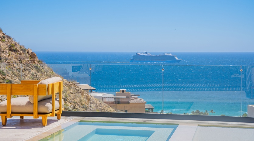 Breathtaking sea views stretch endlessly from this hillside terrace, featuring a pristine pool and luxury daybed for ultimate relaxation.
