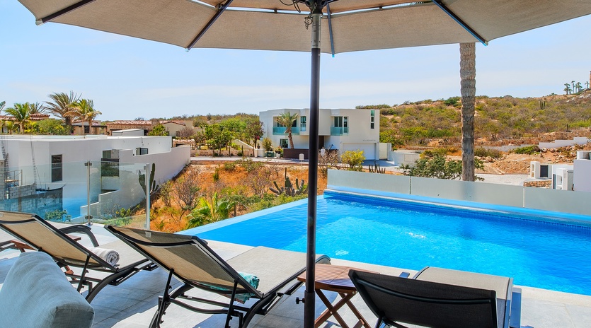 Sunny poolside patio with lounge chairs