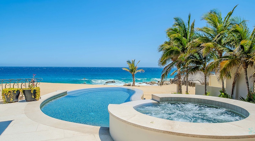 Soak in your private hot tub steps from the pool, with swaying palms, golden sand, and endless turquoise ocean stretching before you—pure beachfront bliss.