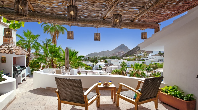 Your private terrace invites relaxation with comfortable seating overlooking tropical palms and mountain views—perfect for morning coffee or evening cocktails.