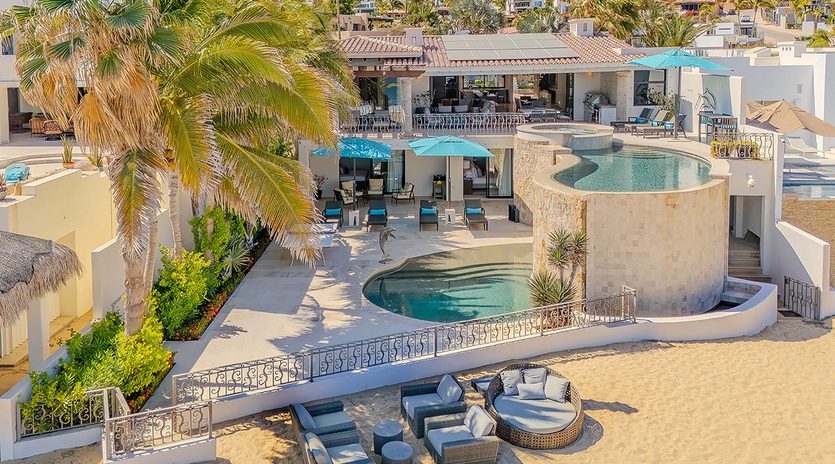 Spectacular hillside villa with multiple pools and terraces set against a scenic coastal backdrop, offering luxurious indoor-outdoor living spaces throughout the property.