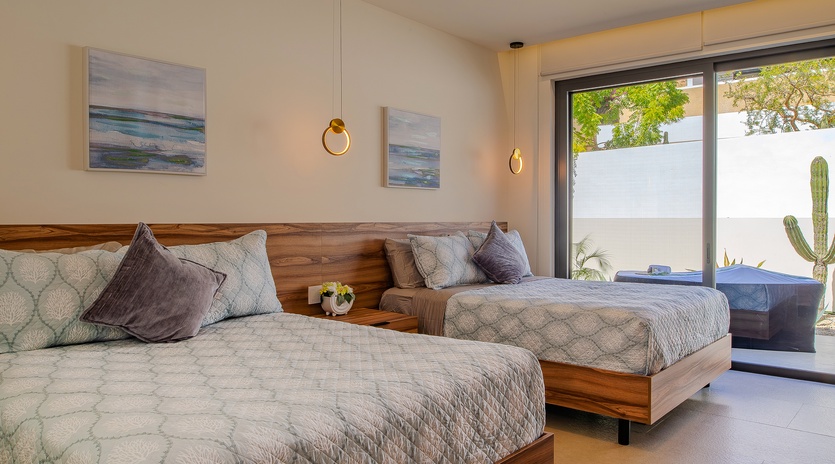 Drift into dreams on plush twin beds with stunning modern design, warm wood accents, and peaceful garden views through expansive windows.