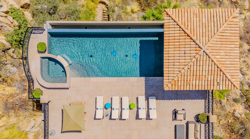 Aerial view of the property showcasing the swimming pool and outdoor terrace surrounded by natural landscape.