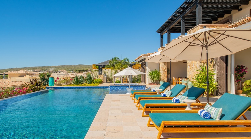 Luxurious poolside retreat with crystal-clear waters and comfortable loungers under sunny skies.