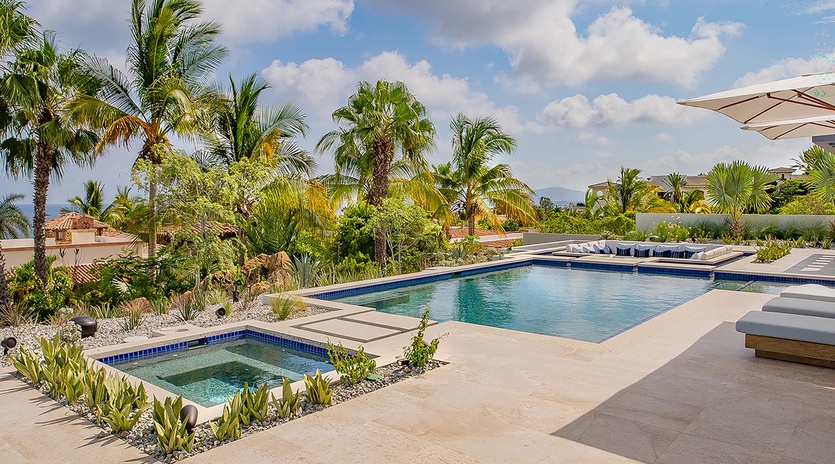 Sink into your poolside lounge under swaying palms, with a sparkling pool and hot tub ready for your refreshing escape in this tropical paradise.