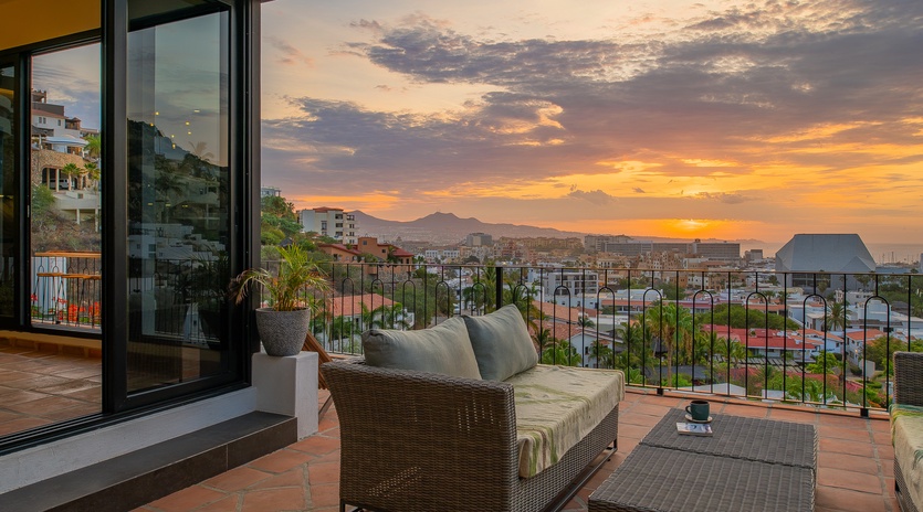 A terrace overlooking the city at sunset, featuring comfortable seating where guests can unwind while taking in mountain and urban views from the property.