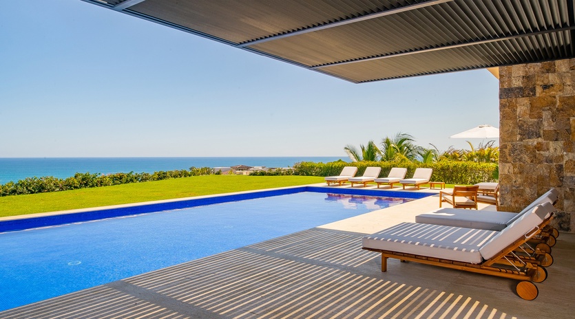Beautiful patio with lounge chairs by the pool and ocean views