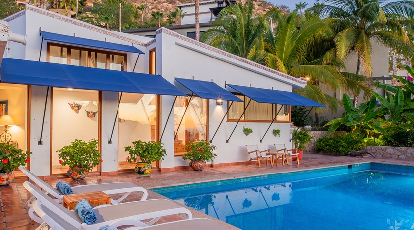 Poolside view of villa exterior during evening