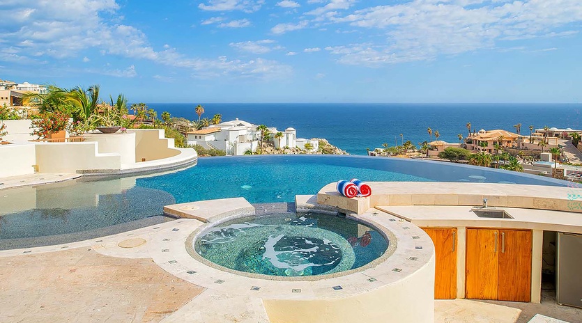 Stunning infinity pool and built-in hot tub overlook the sparkling ocean, creating your own private oasis under endless blue skies.