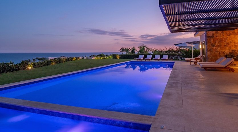 Pool and jacuzzi with ocean view during sunset