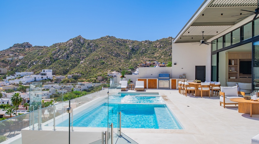 Modern luxury villa featuring a pristine pool and scenic mountain backdrop in an exclusive hillside location.