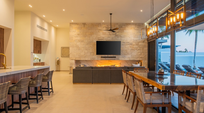 Relax in your elegant open-plan living space with stone fireplace, modern kitchen, and oceanview dining for unforgettable vacation moments.