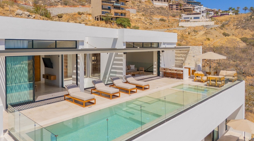 Modern architectural villa nestled in hillside terrain, featuring contemporary design and panoramic views of the surrounding landscape.