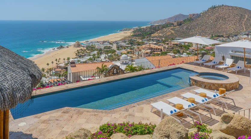 Stunning oceanfront property featuring infinity pool with panoramic views of pristine beaches and dramatic coastal mountains.