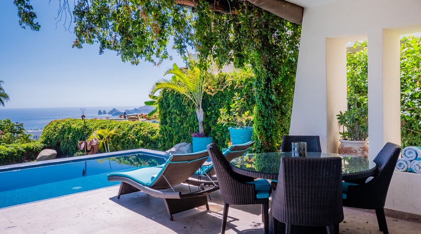 Poolside patio with shady seating area and ocean views