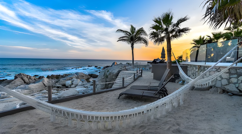 Lounge in a cozy hammock during sunset at the Santa Carmela Beach Club